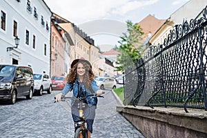 Beautiful young woman tourist traveller with electric scooter in small town.