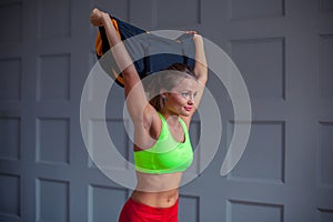 Beautiful young woman is training with a sandbag in the gym.