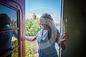 Beautiful young woman in a traveler hat in a carriage on a train in Sri Lanka traveling to Asia,