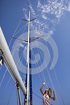 Beautiful young woman traveling along Mediterranean sea on sail boat