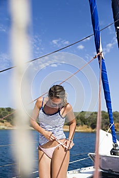 Beautiful young woman traveling along Mediterranean sea on sail boat
