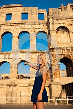 Beautiful young woman turist taking photos of roman arena in Pul