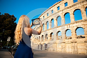 beautiful young woman turist taking photos of roman arena in Pula croatia