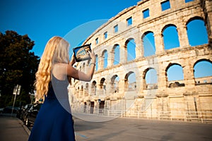 beautiful young woman turist taking photos of roman arena in Pula croatia