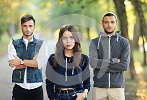 Beautiful young woman and two men behind her