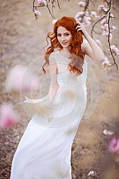 Beautiful young woman under the flowering tree