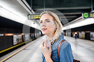 Beautiful young woman at the underground platform, waiting