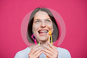 Beautiful young woman uses an oral care kit consisting of a tongue scraper, single tufted and interdental brush