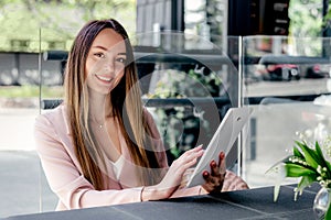 Beautiful young woman using digital tablet at cafe photo