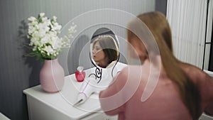 Beautiful young woman is using a hair dryer while looking into the mirror in room