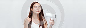 Beautiful young woman using hair dryer on white background. Panorama