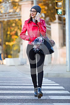 Beautiful young woman using her mobile phone in the city.