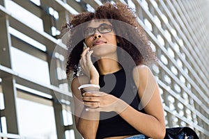 Beautiful young woman using her mobile phone in the street.