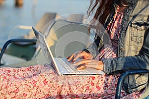 Beautiful young woman using laptop at beach