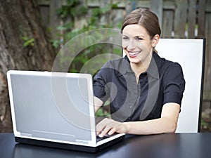 Beautiful young woman using laptop Outside