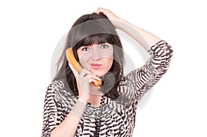 Beautiful young woman using retro orange telephone