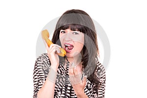 Beautiful young woman using retro orange telephone