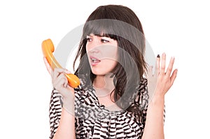 Beautiful young woman using retro orange telephone