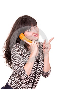 Beautiful young woman using retro orange telephone