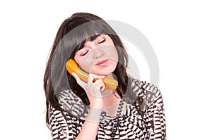 Beautiful young woman using retro orange telephone