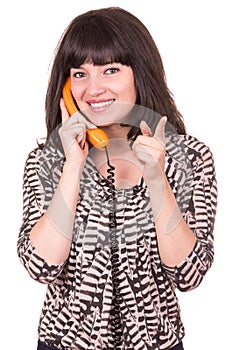 Beautiful young woman using retro orange telephone