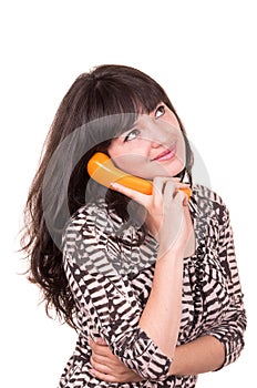 Beautiful young woman using retro orange telephone