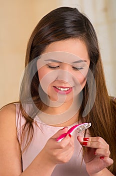 Beautiful young woman using a shaver on her hair, bath background