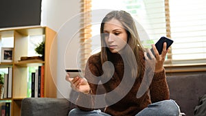 Beautiful young woman using smartphone shopping online with credit card at home