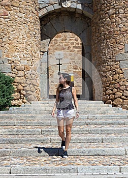 Beautiful young woman using sunglasses walking down a staircase at Mazanares El Real Castle in Spain. Portrait of woman looking to