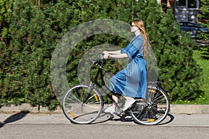 Beautiful young woman and vintage bicycle, summer. Red hair girl riding the old black retro bike outside in the park