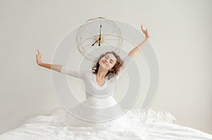 Beautiful young woman waking up and stretching in her bed in the morning