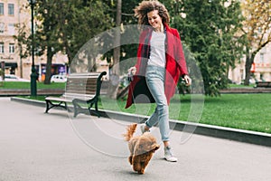 Beautiful young woman on a walk with cute poodle dog
