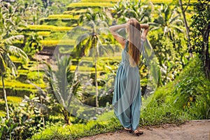 Beautiful young woman walk at typical Asian hillside with rice farming, mountain shape green cascade rice field terraces