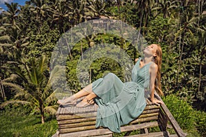 Beautiful young woman walk at typical Asian hillside with rice farming, mountain shape green cascade rice field terraces