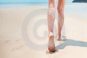 Beautiful young woman is walking along a seashore