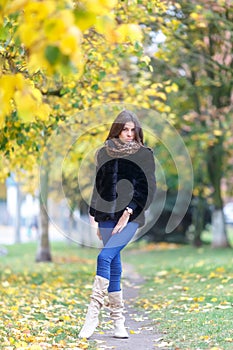 Beautiful young woman walking in autumn park. Autumn fashin concept.