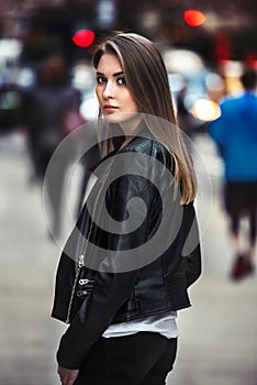 Beautiful young woman walking on the crowdy street photo