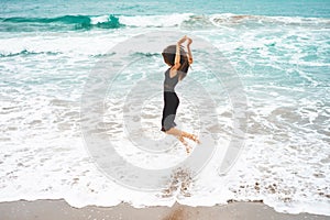 Beautiful young woman walking at the sea