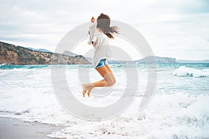 Beautiful young woman walking at the sea