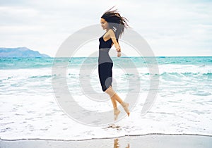 Beautiful young woman walking at the sea