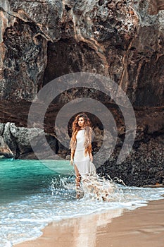 Beautiful young woman walking by the shore line