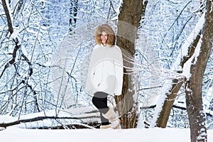 Beautiful young woman walking in a snowy park