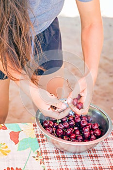 beautiful young woman washes cherries