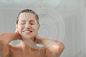 Beautiful young woman washing hair in shower at home. Space for text