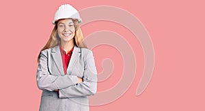 Beautiful young woman wearing architect hardhat happy face smiling with crossed arms looking at the camera