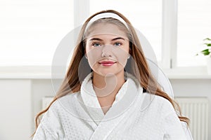 Beautiful young woman wearing bathrobe. Face care, Facial treatment, Cosmetology, beauty and spa Concept