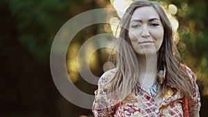 Beautiful young woman wearing bohostyle clothes posing in the rays of the evening sun, sunset. Boho style fashion