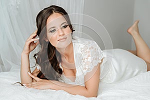 Beautiful young woman wearing casual lingerie. Fashion portrait of young elegant woman in bed. Bride in the bed