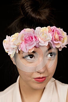 Beautiful young woman wearing a floral crown looking up