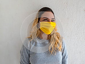 Beautiful young woman wearing a medical face mask. Wearing casual clothes and standing against a white background